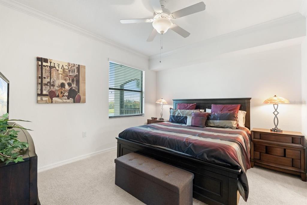 16904 Vardon Terrace, Unit 301 Lakewood Ranch, FL 34211 - Photo 16 of 28 a bedroom with a bed and a chandelier