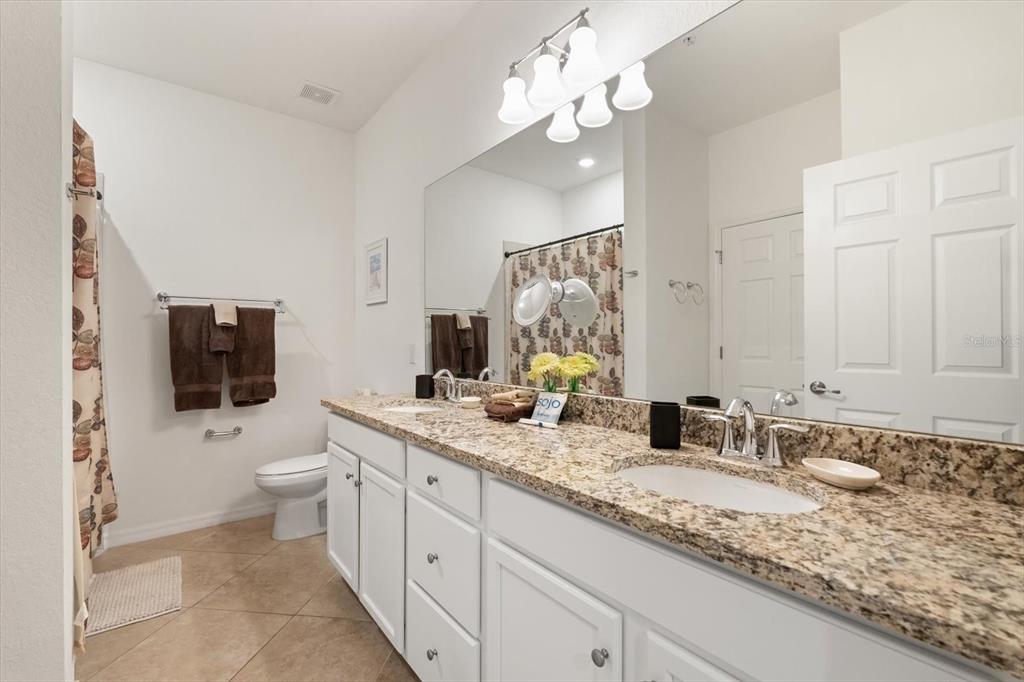 16904 Vardon Terrace, Unit 301 Lakewood Ranch, FL 34211 - Photo 20 of 28 a bathroom with a granite countertop sink a toilet a mirror and shower