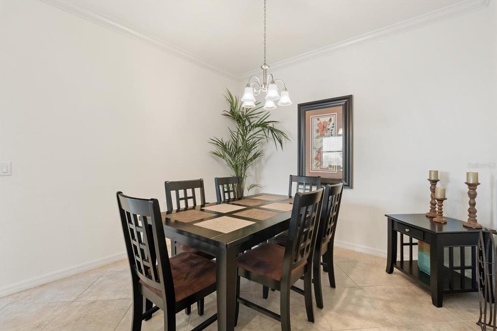 16904 Vardon Terrace, Unit 301 Lakewood Ranch, FL 34211 - Photo 5 of 28 a view of a dining room with furniture and chandelier