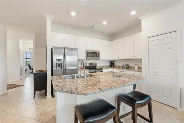 a kitchen with kitchen island granite countertop a stove and cabinets