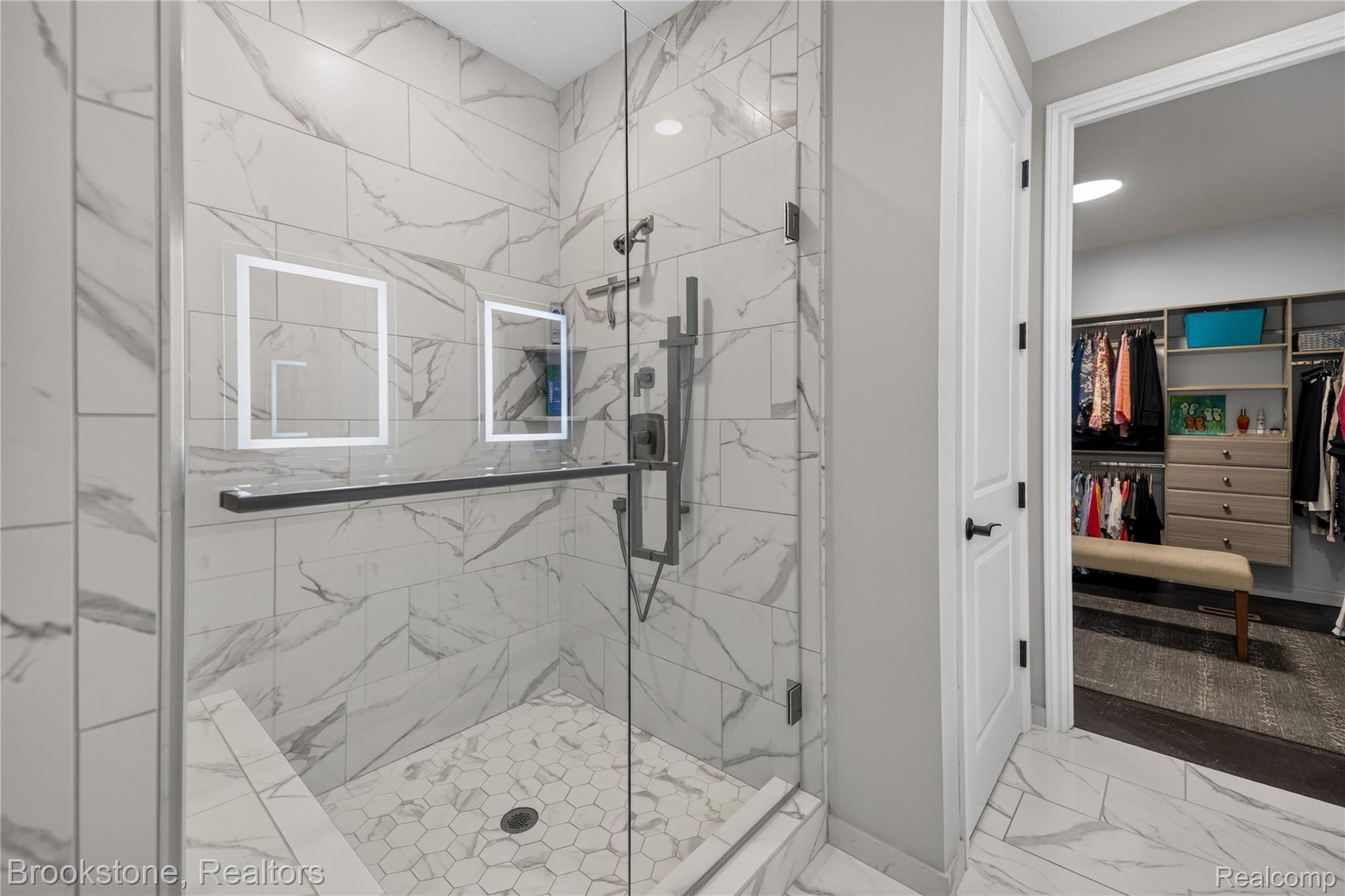 2167 Sanctuary Court Rochester, MI 48309 - Photo 51 of 68 Walk-in shower featuring full-height marble-look tile, frameless glass enclosure, built-in bench, and dual shower heads