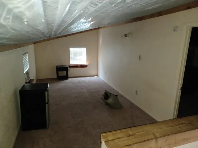 a view of a livingroom with an empty space and a window