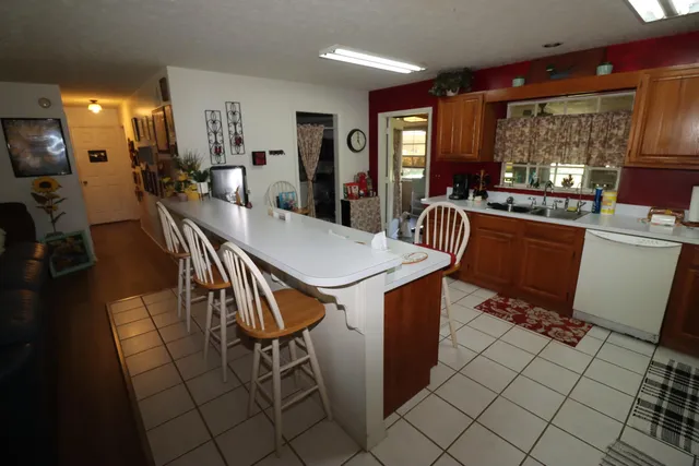 a kitchen with stainless steel appliances granite countertop table chairs sink and cabinets
