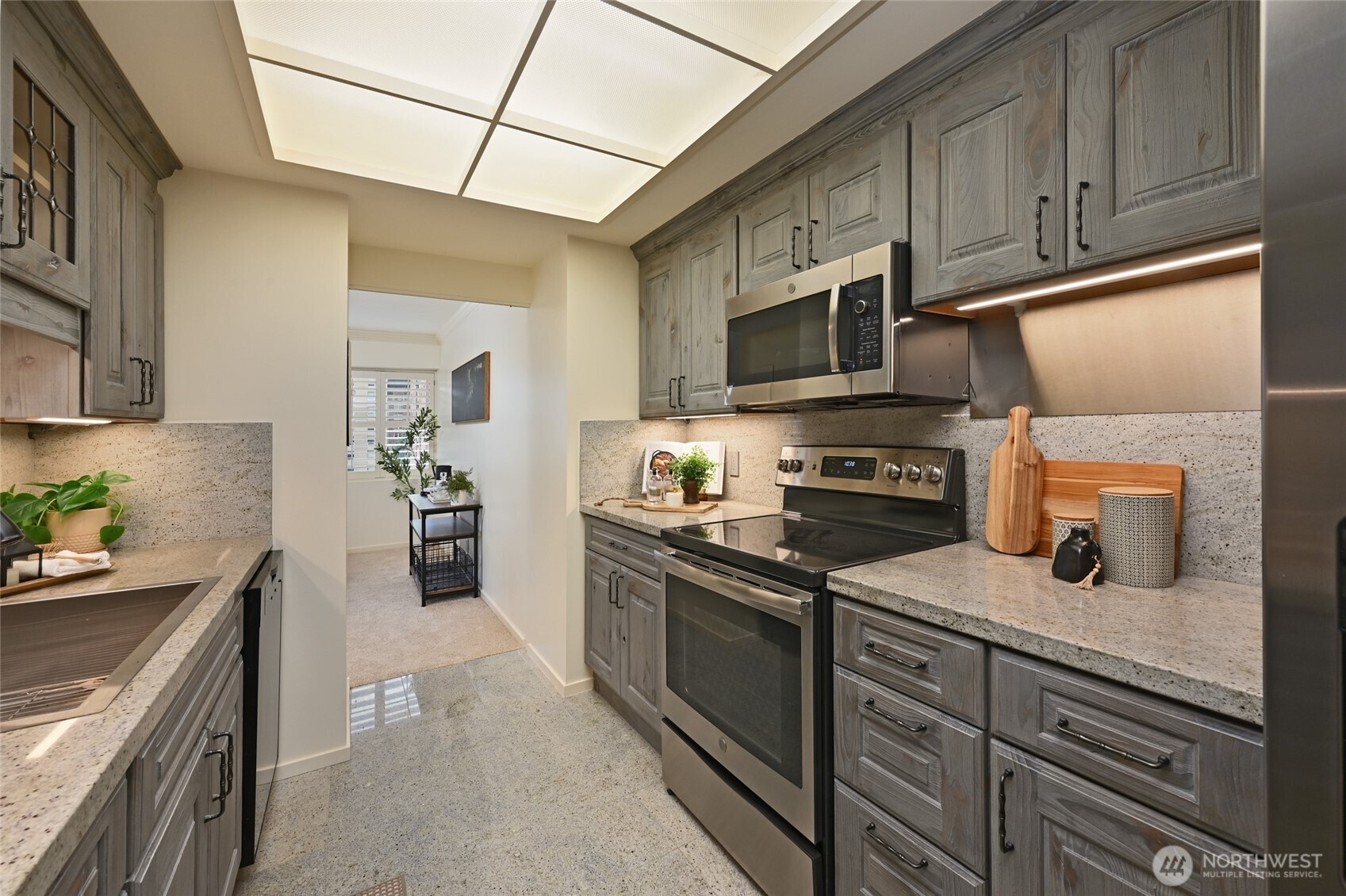1301 Spring Street, Unit 6D Seattle, WA 98104 - Photo 10 of 29 a kitchen with stainless steel appliances granite countertop a refrigerator stove and sink