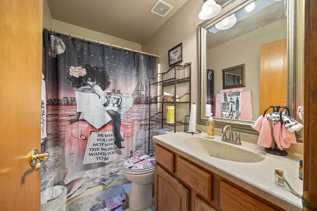 a bathroom with a sink vanity mirror and toilet