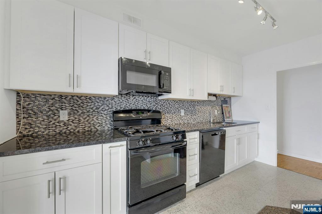 6 Horizon Road, Unit 1508 Fort Lee, NJ 07024 - Photo 20 of 46 a kitchen with stainless steel appliances granite countertop a stove a sink and a microwave
