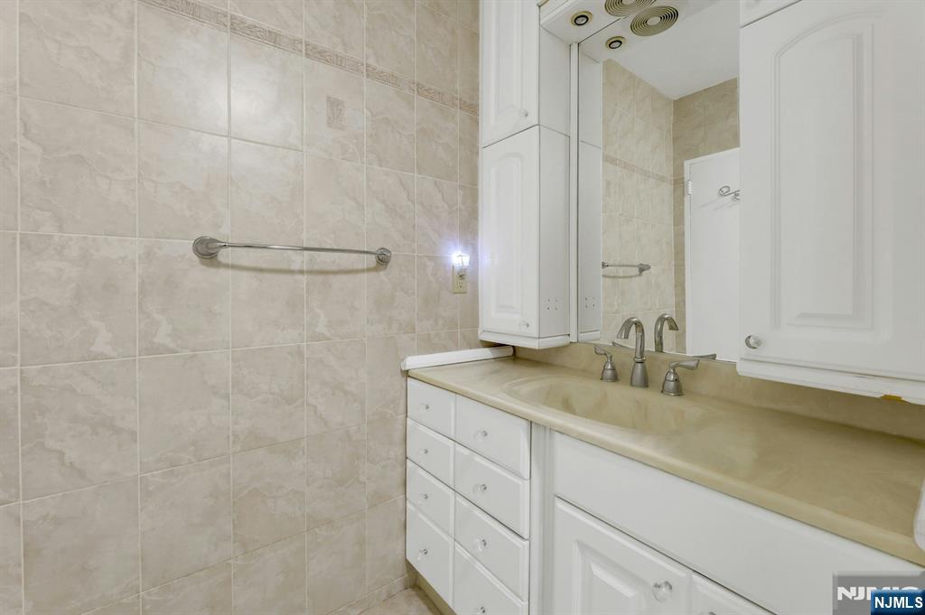 6 Horizon Road, Unit 1508 Fort Lee, NJ 07024 - Photo 36 of 46 a bathroom with a granite countertop sink and a mirror