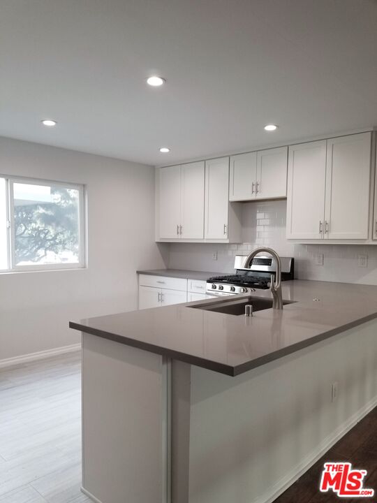 a kitchen with stainless steel appliances granite countertop a sink stove and cabinets