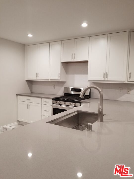 4866 1/2 McConnell Avenue Los Angeles, CA 90066 - Photo 2 of 11 a kitchen with stainless steel appliances granite countertop a sink stove and white cabinets