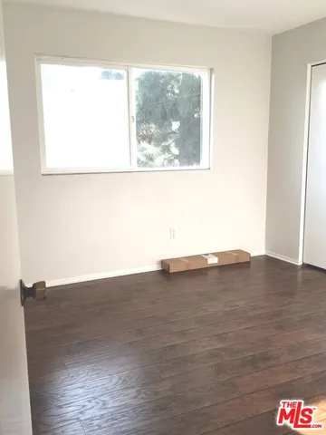 a view of a room with wooden floor and a window