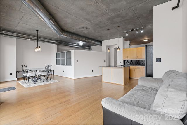 a living room with furniture and kitchen view