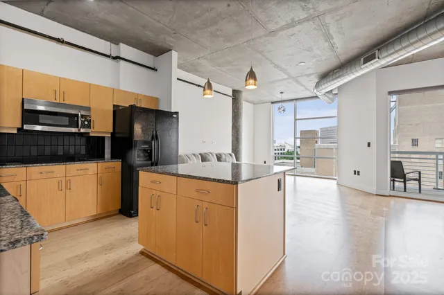 a kitchen with stainless steel appliances kitchen island granite countertop a refrigerator and a stove top oven