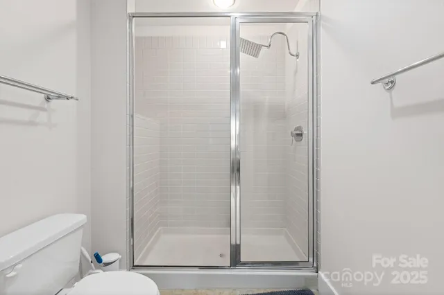 a bathroom with a shower a toilet and a sink