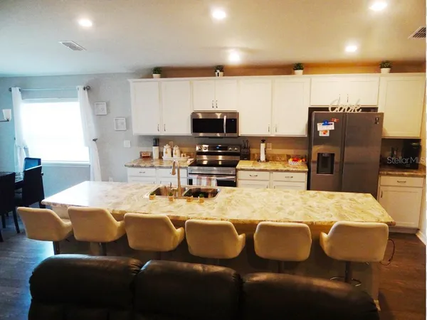 a kitchen with a dining table chairs and refrigerator
