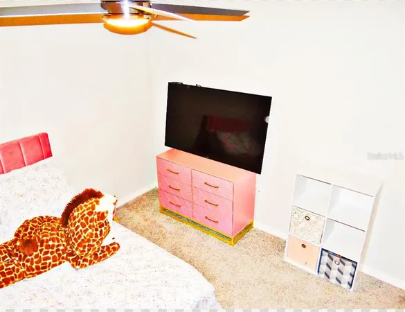 a living room with a flat screen tv on dresser and a table