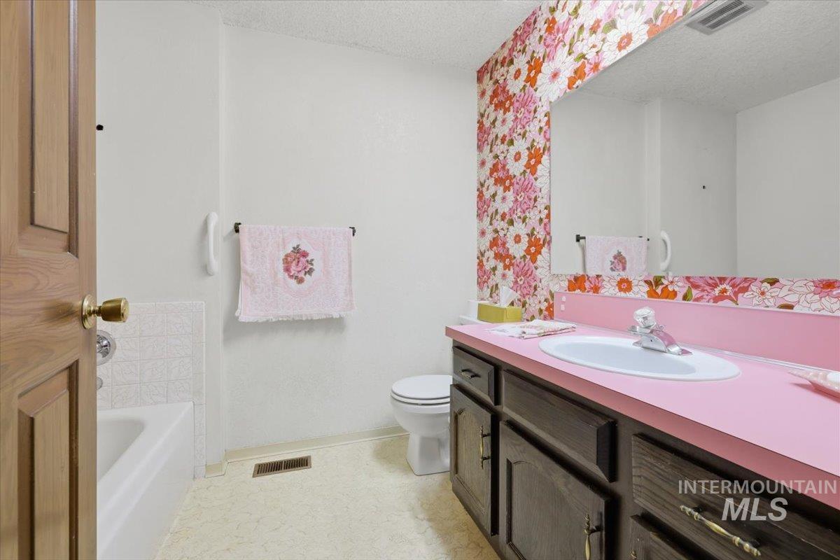1311 North Middleton Road Nampa, ID 83651 - Photo 21 of 49 Bathroom featuring a built-in vanity with dark wood-finish cabinetry, a pink countertop, and an integrated basin