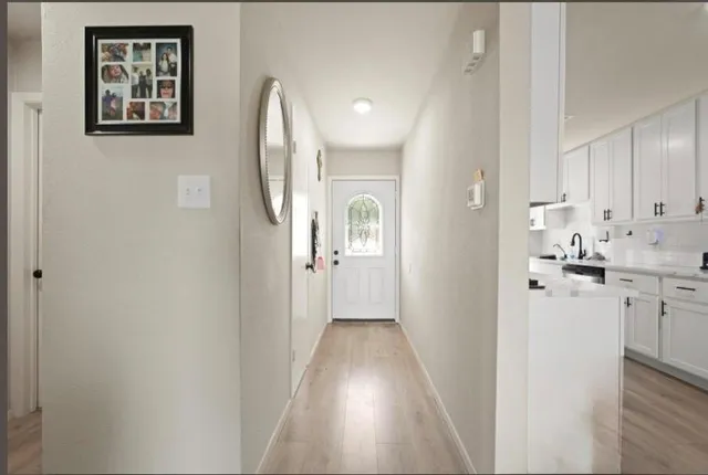 a view of a hallway with wooden floor