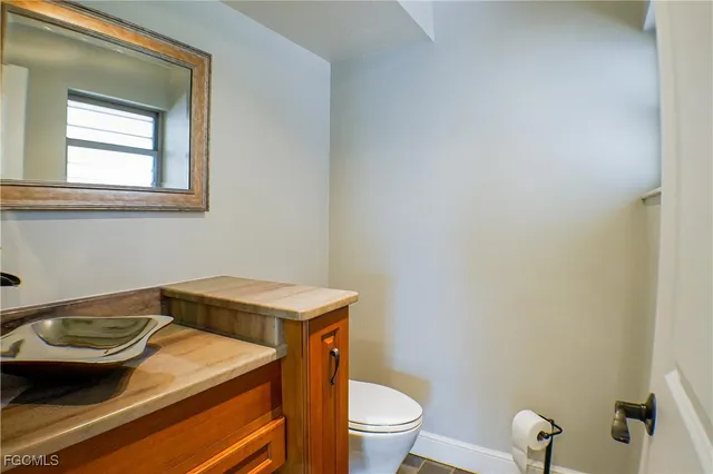 a bathroom with a sink a toilet and a window