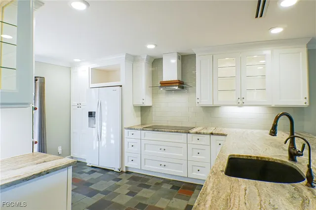 a kitchen with granite countertop a sink a stove and cabinets