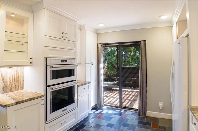 a kitchen with white cabinets and white appliances