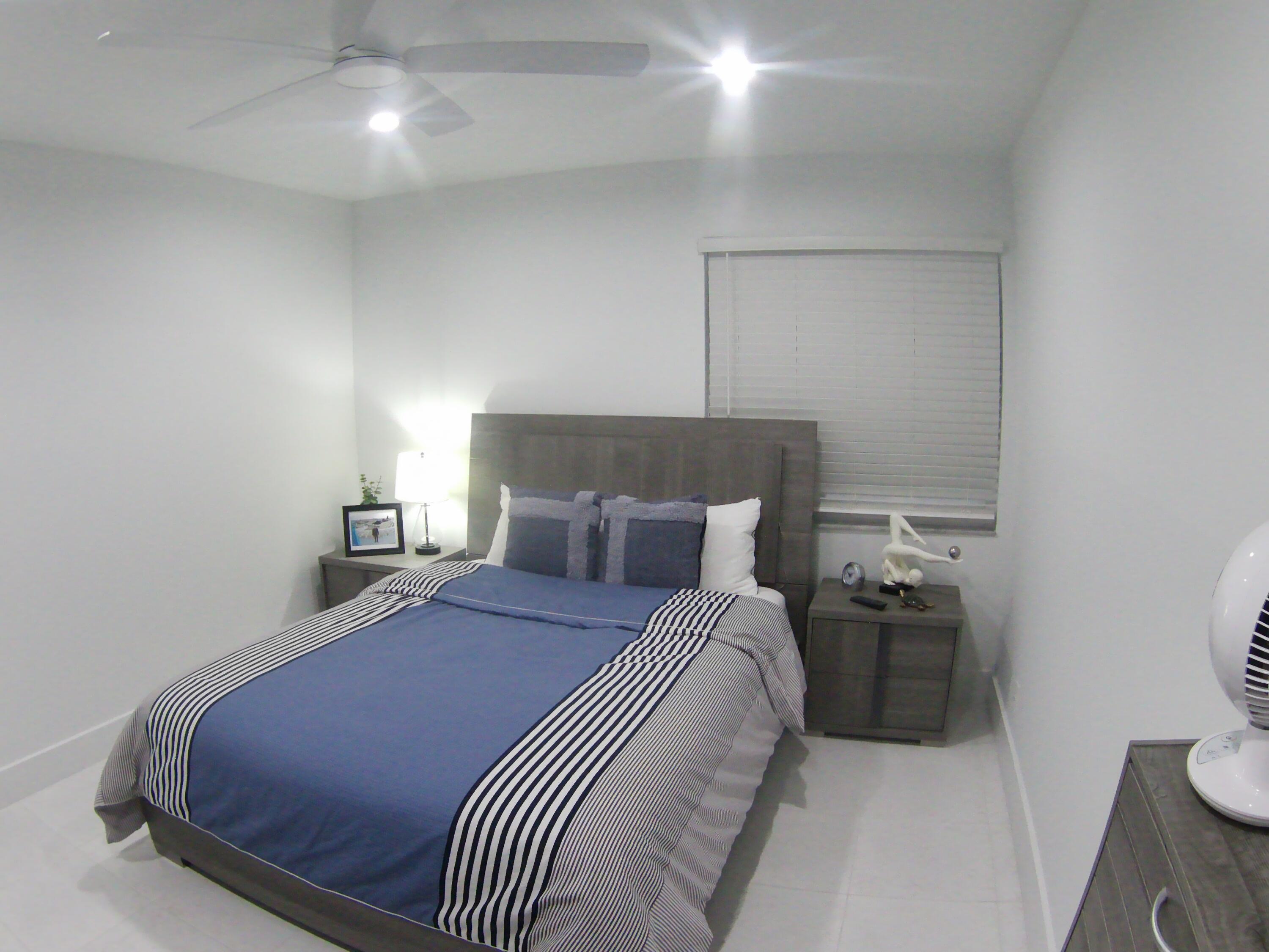 541 Normandy Lane Delray Beach, FL 33484 - Photo 18 of 23 a bedroom with a bed and a lamp with the bathroom