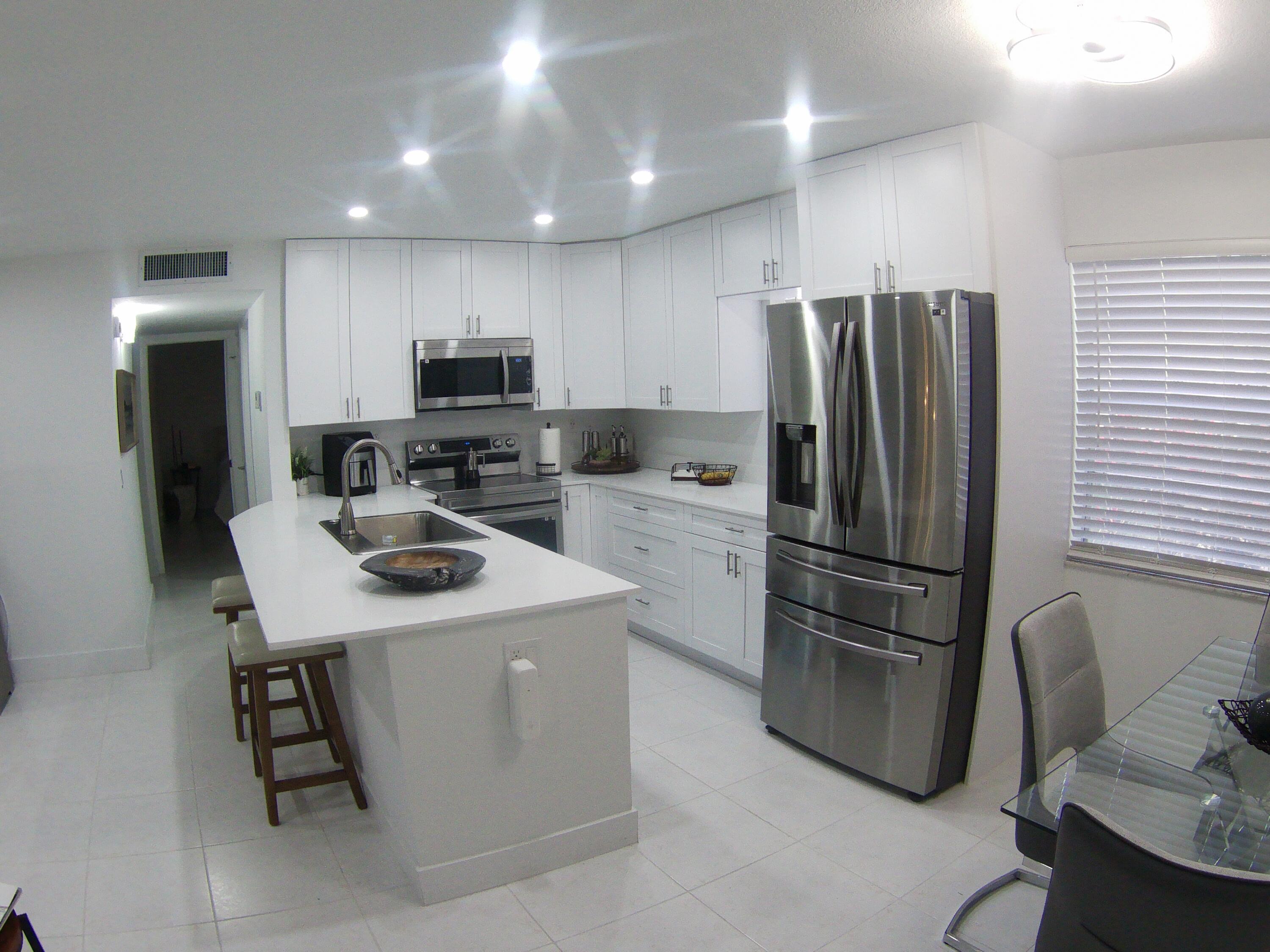 541 Normandy Lane Delray Beach, FL 33484 - Photo 7 of 23 a kitchen with a refrigerator a microwave a sink and a stove