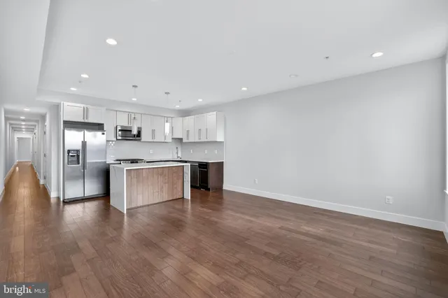 a open kitchen with white cabinets and stainless steel appliances