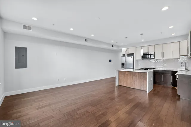 a large kitchen with stainless steel appliances granite countertop a large counter top a sink and a stove