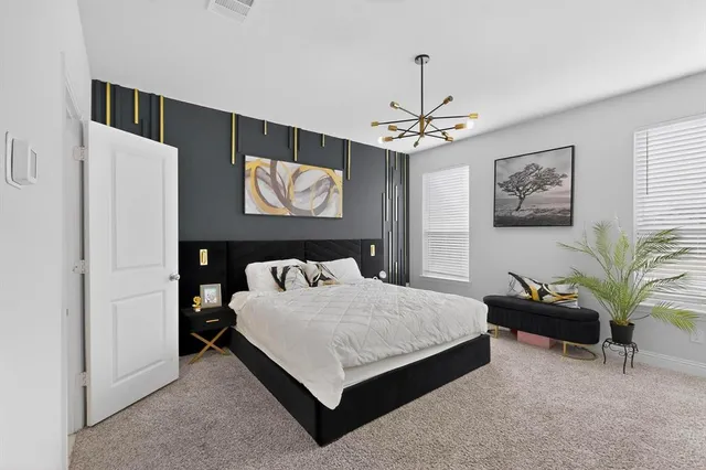 a bedroom with a bed and a chandelier