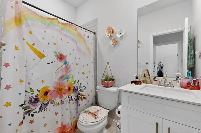 a bathroom with a sink mirror vanity and toilet