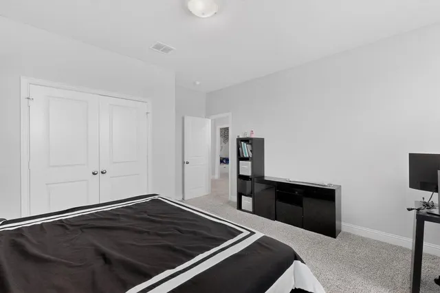 a bedroom with a bed and flat screen tv