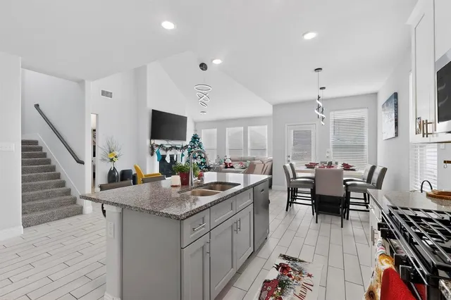 a kitchen with sink refrigerator and dining table