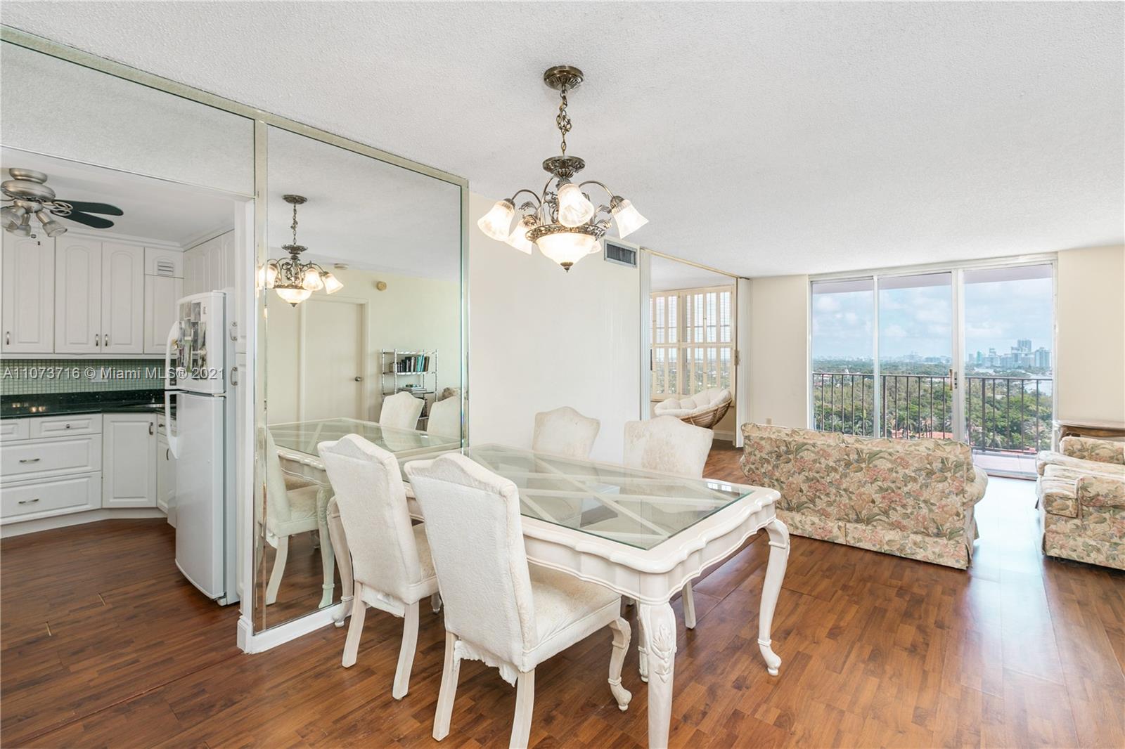 4101 Pine Tree Drive, Unit 1410 Miami Beach, FL 33140 - Photo 3 of 28 a view of a dining room with furniture window and wooden floor
