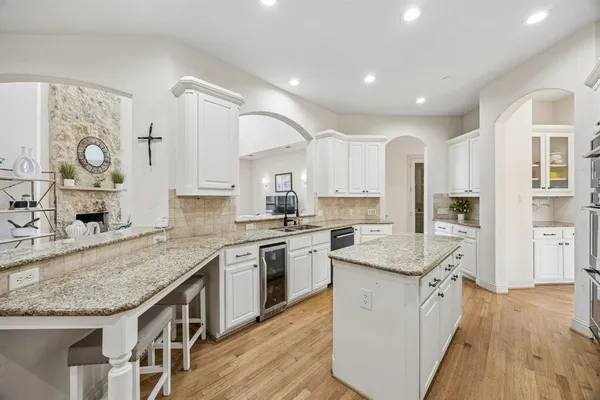 a kitchen with granite countertop kitchen island a sink stove and wooden cabinets
