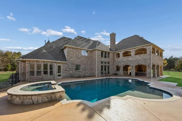 a front view of a house with swimming pool and yard
