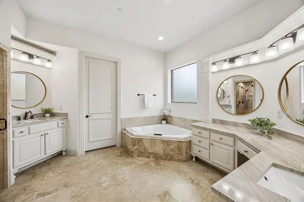 a spacious bathroom with a double vanity sink mirror and bathtub