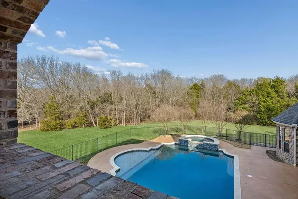 a view of yard with swimming pool and green space