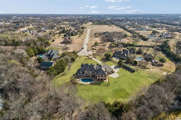 an aerial view of a house with a yard and lake view