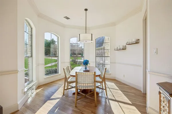 a dining room with furniture a chandelier and wooden floor