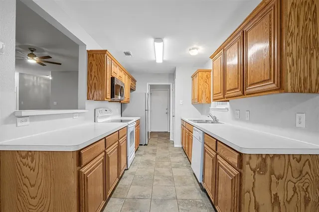 a kitchen with stainless steel appliances granite countertop a sink and dishwasher a oven with wooden cabinets