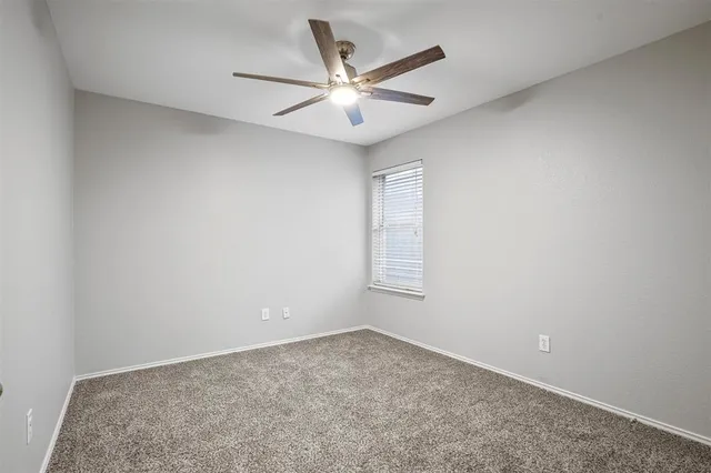 a view of a livingroom with a ceiling fan and window