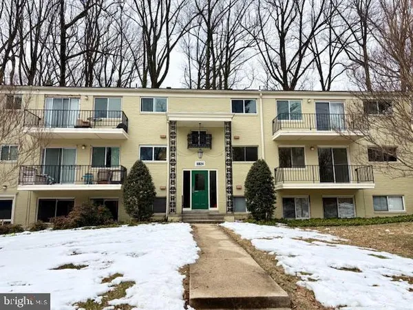 a front view of a residential apartment building with a yard
