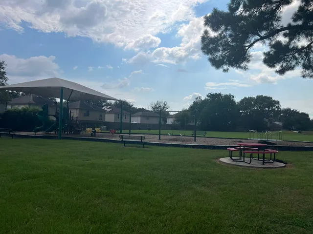 a view of a green field with wooden fence