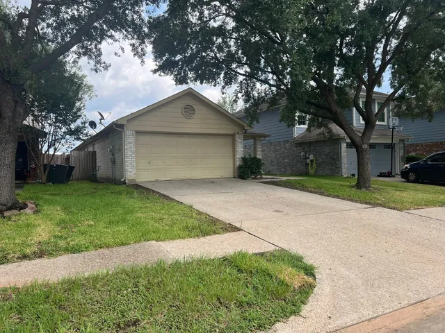 a front view of a house with a garden and trees
