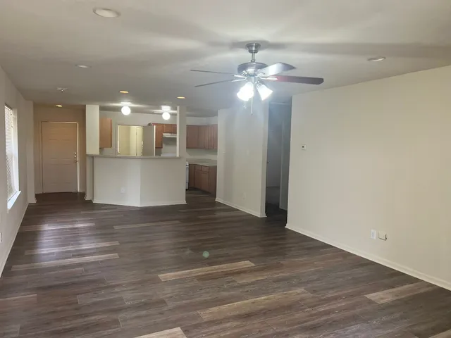 a view of a room with wooden floor and ceiling fan