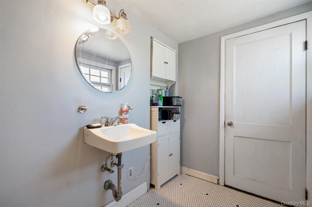 217-19 39th Avenue Queens, NY 11361 - Photo 14 of 38 a bathroom with a sink a mirror and a window
