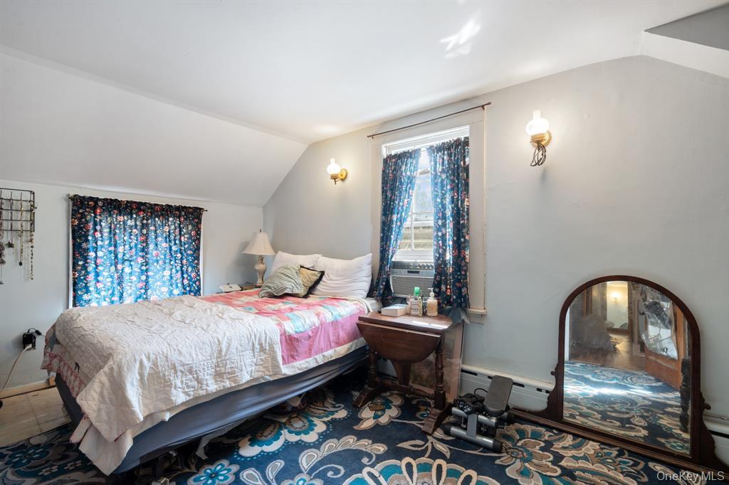 217-19 39th Avenue Queens, NY 11361 - Photo 15 of 38 a bedroom with a bed and a mirror on dresser