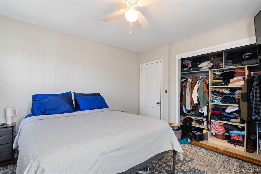 217-19 39th Avenue Queens, NY 11361 - Photo 19 of 38 a bedroom with a bed a walk in closet and a window