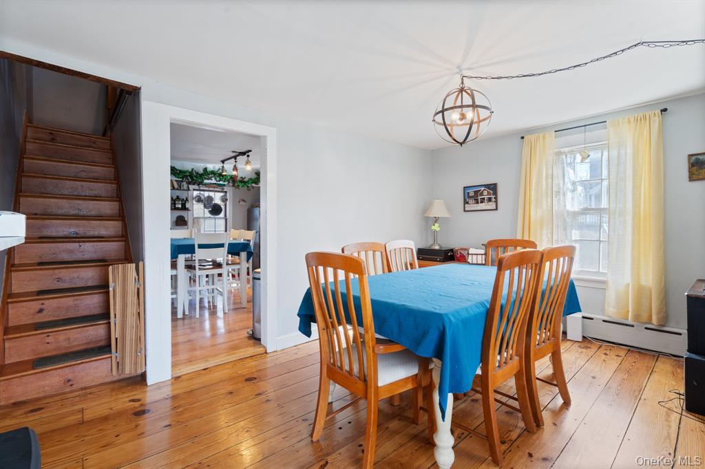 217-19 39th Avenue Queens, NY 11361 - Photo 6 of 38 a dining room with furniture wooden floor a rug and a painting