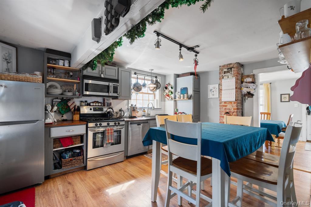 217-19 39th Avenue Queens, NY 11361 - Photo 10 of 38 a kitchen with stainless steel appliances kitchen island granite countertop a table chairs stove and refrigerator